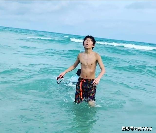原创张柏芝儿子海边戏水，肤色黝黑腹肌初现，颜值身材像谢霆锋