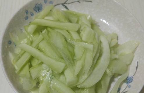 第二步:切好片的白瓜装在一个盘子中,在上面撒一勺盐,让白瓜出一些