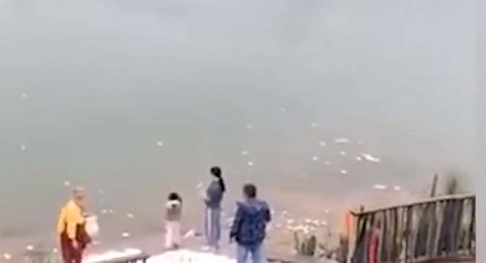 市民不停将大量馒头扔进江中场面惊人 旁边还站着一个僧人