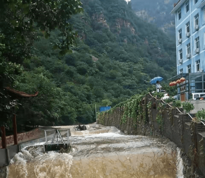 承德兴隆天子山聚仙阁农家院,房屋被果树包围,门前还有小河流淌