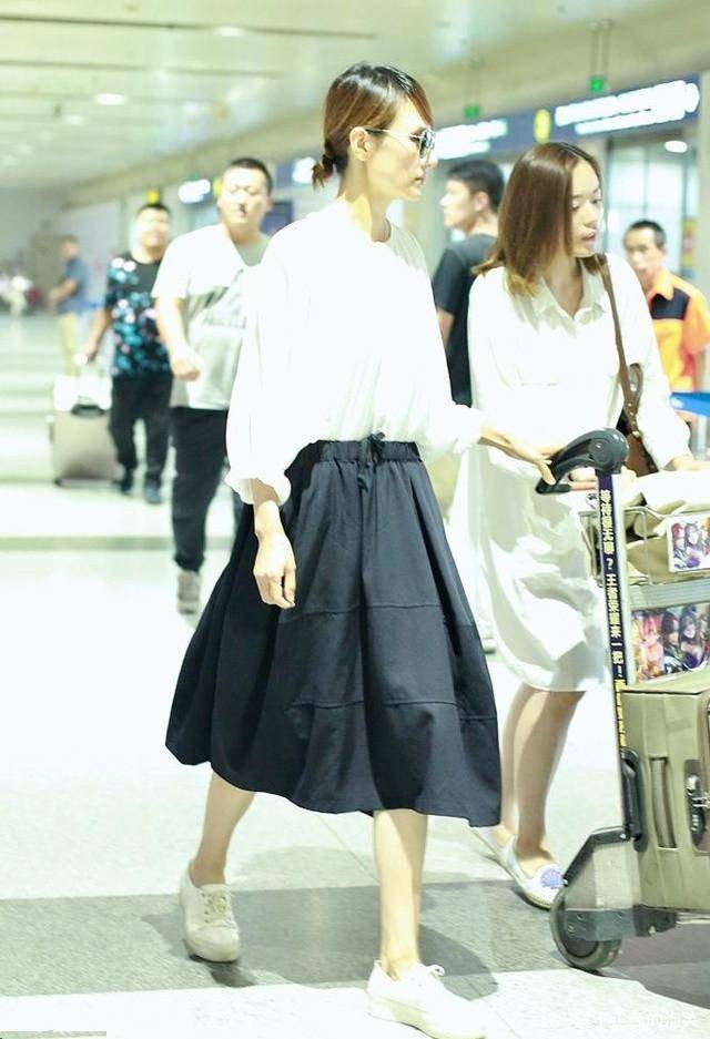 街拍中的袁泉,浅色衬衣搭驼色半身裙,像个18岁的女大学生一样