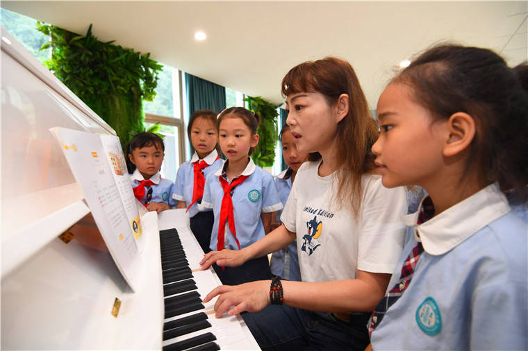 贵阳市南明区花果园第二小学的老师正在该校音乐角带着学生唱儿歌