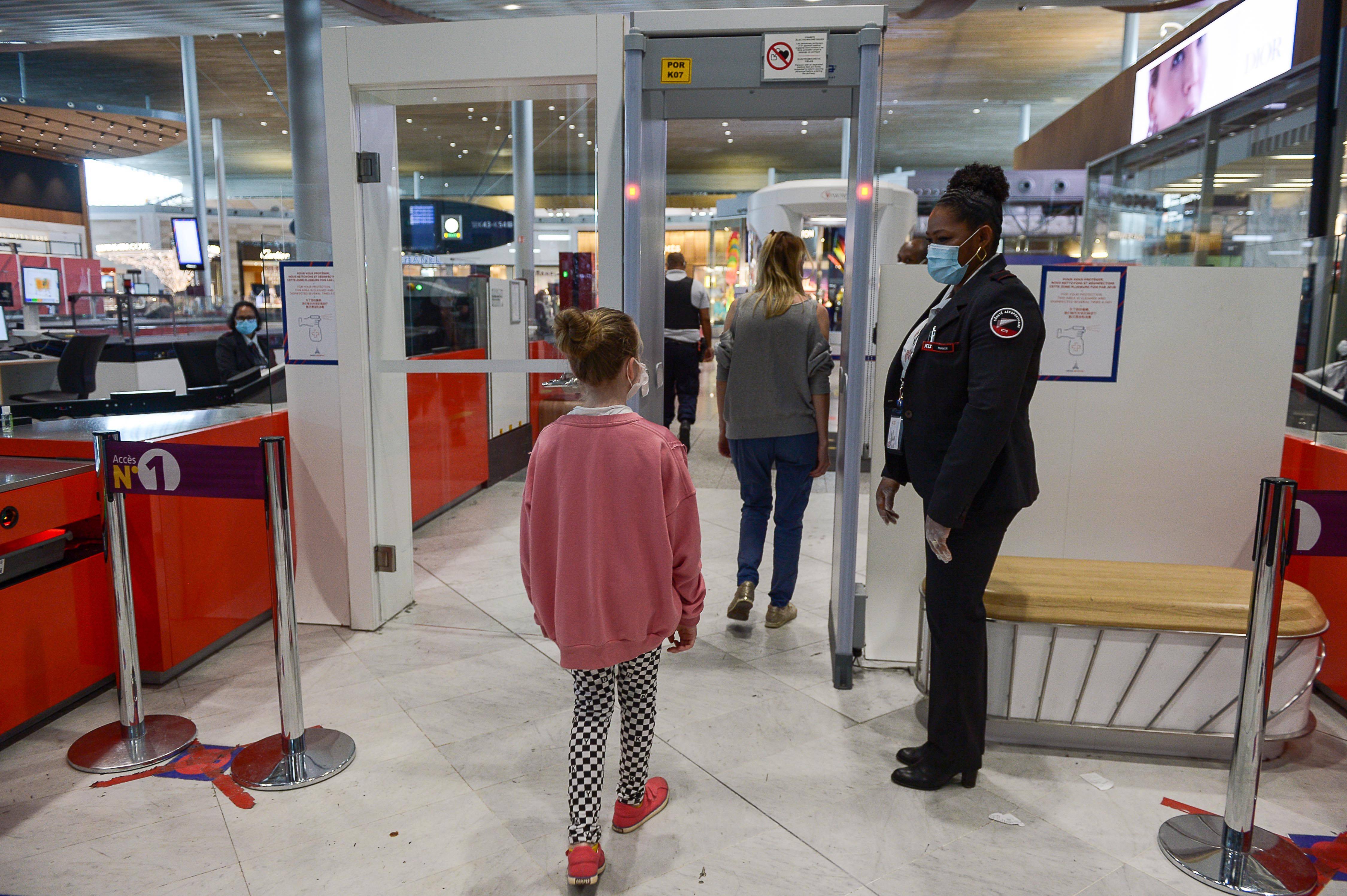 6月12日,在法国巴黎戴高乐机场二号航站楼,旅客通过安检门.