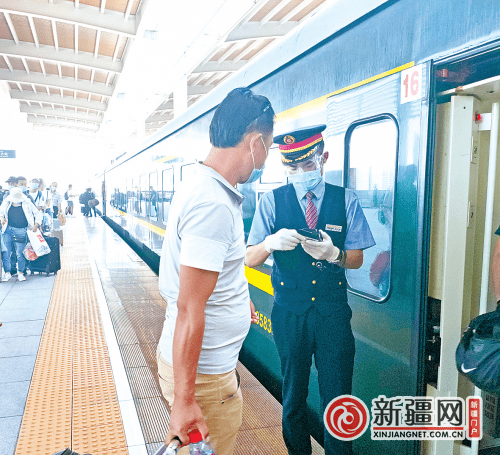 乌鲁木齐至北京西z70次列车工作人员正在用手持终端为旅客检票上车.