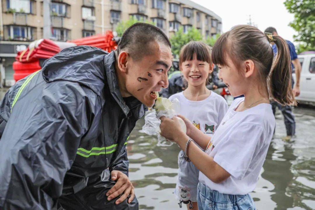 (图为 张钰兰,张钰琳双胞胎小志愿者正在喂消防指战员肖博杰吃温暖的