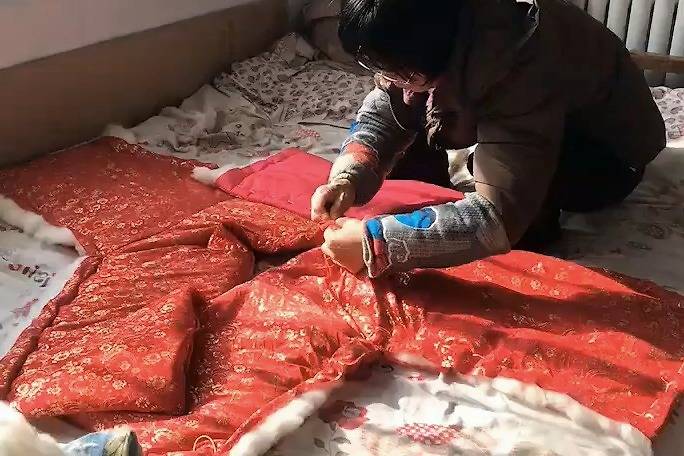 农村妈妈为出嫁的女儿手工缝制小棉袄