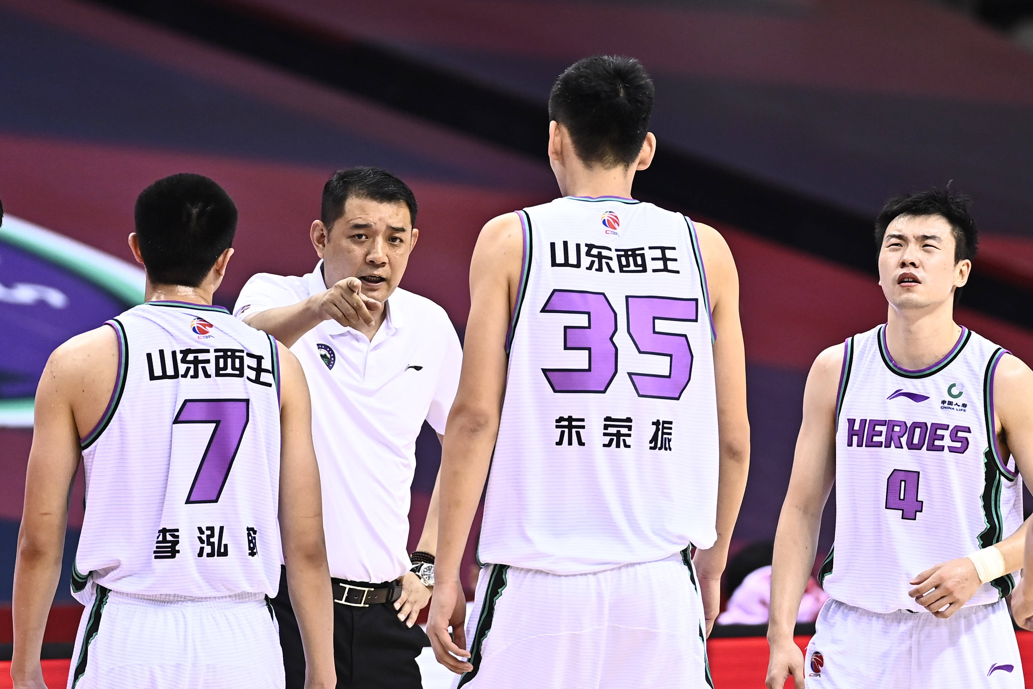 7月24日,山东西王队主教练巩晓彬(左二)在比赛中向球员布置战术.