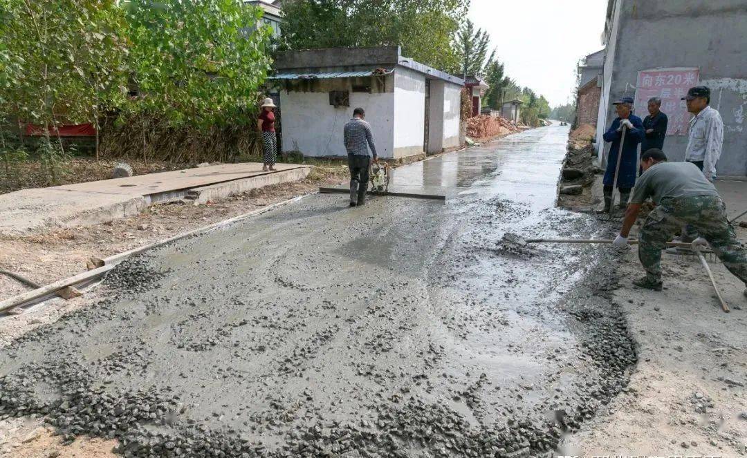 (图:铁富镇张庄村九组,工人正在铺设水泥路)