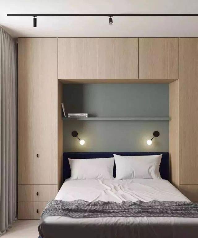 把卧室的床给做成嵌入式的,四周都环绕着柜子,中间留空的区域作为背景
