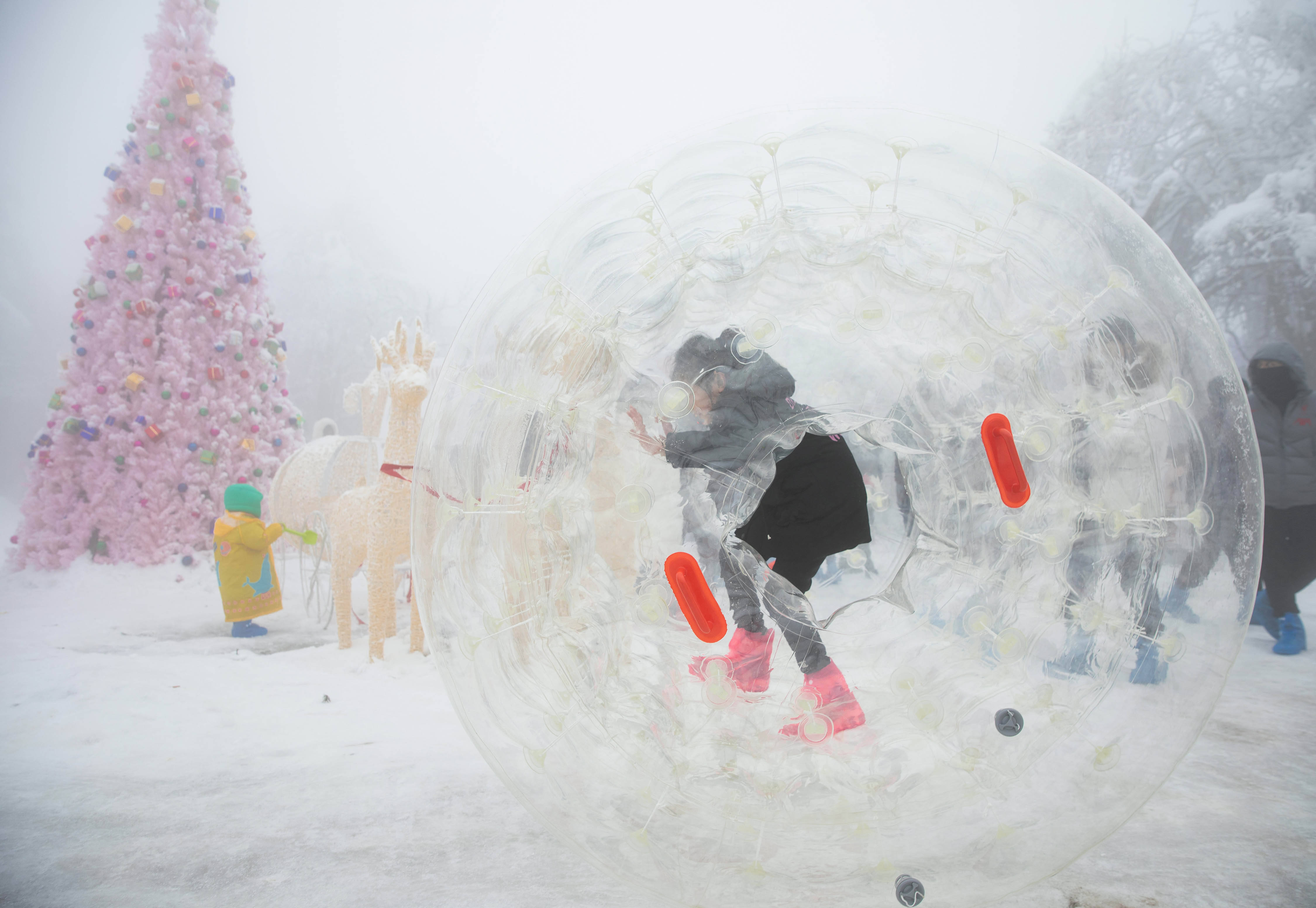 12月12日,在峨眉山雷洞坪滑雪区,一位小朋友在玩雪地悠波球.
