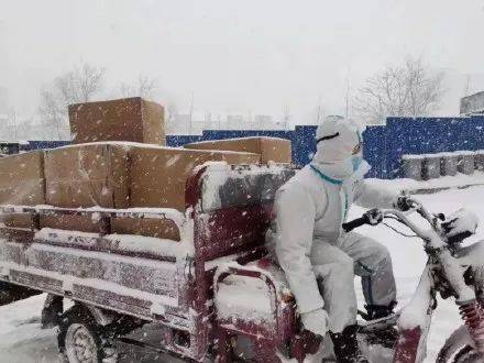 一步一步推行,用三轮车装载防疫物资,师生志愿者们冒着风雪,运送防疫