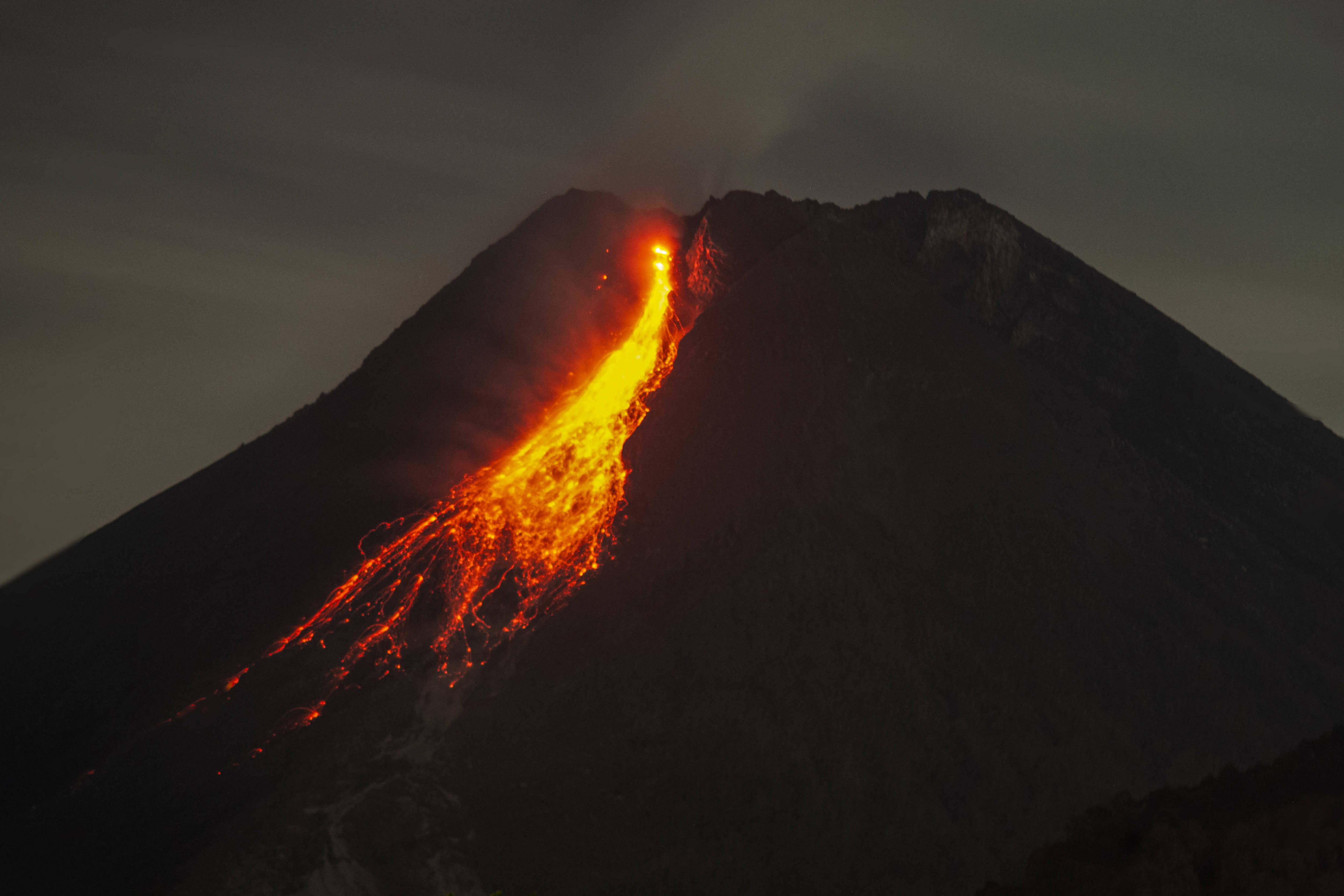 1月20日,在印度尼西亚日惹,人们望向喷发的默拉皮火山(长时间曝光照片