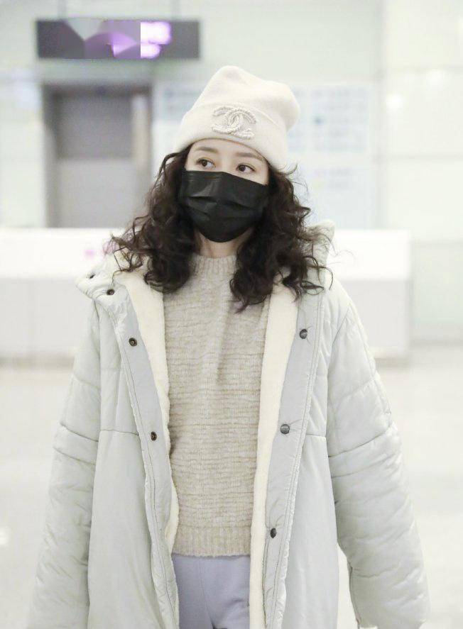 内搭粉色衬衣和白色打底衫,整个造型看上去非常有气质,下半身搭配一条