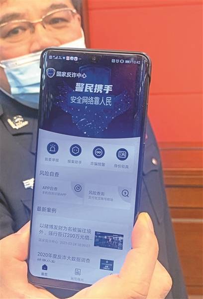 民警展示"国家反诈中心"app 今报记者王斯 摄