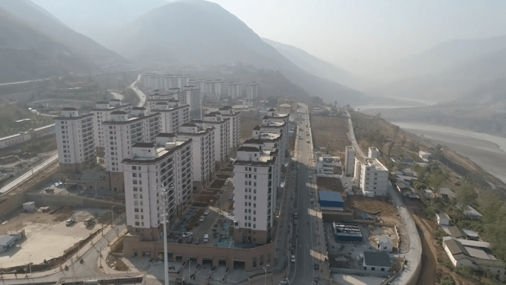 在巧家县移民安置区滨江社区,万鉴毅正在给小区的老家邻居讲解居住