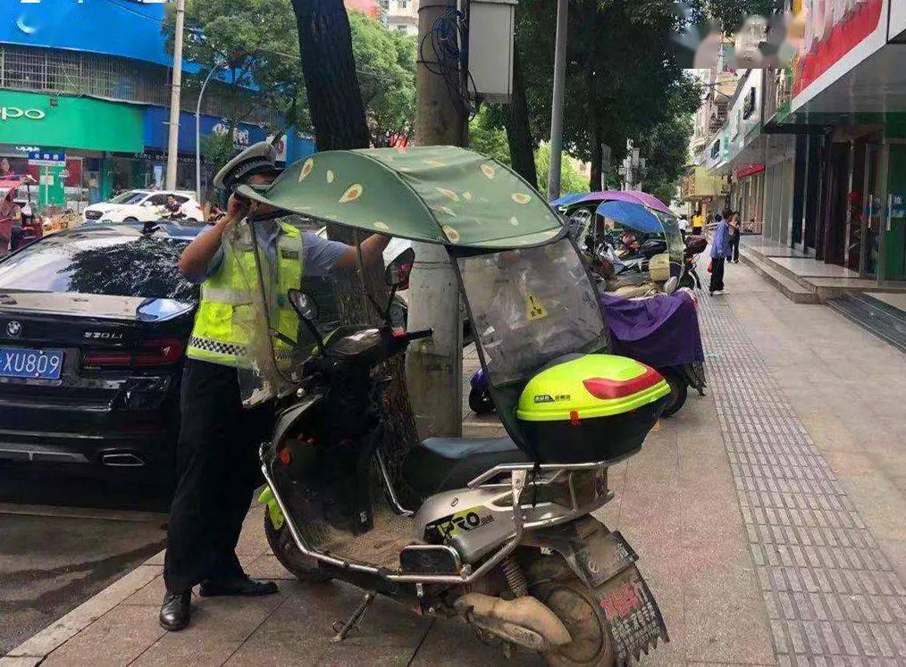 弋阳交警整治电动车加装遮雨篷行动中