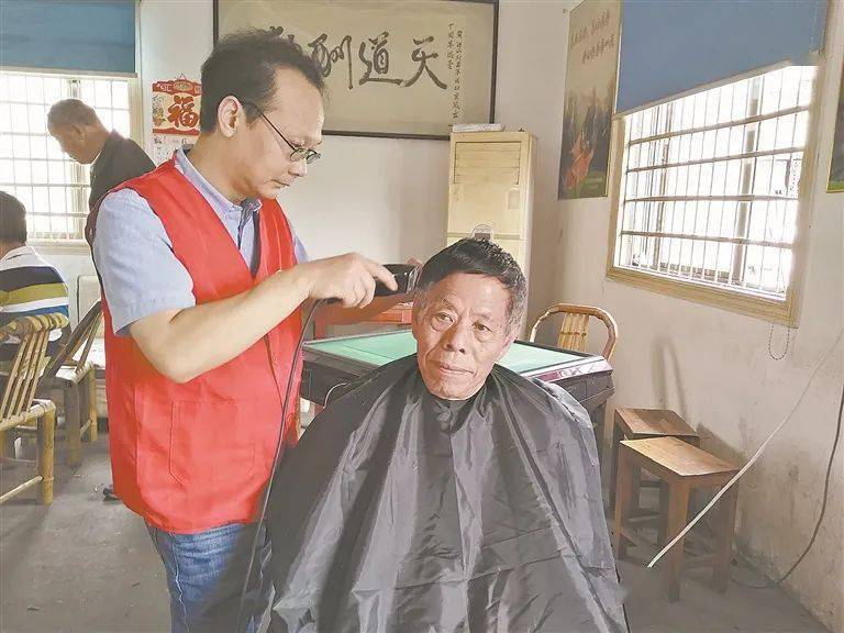 理发师陈华旦在为老人理发.