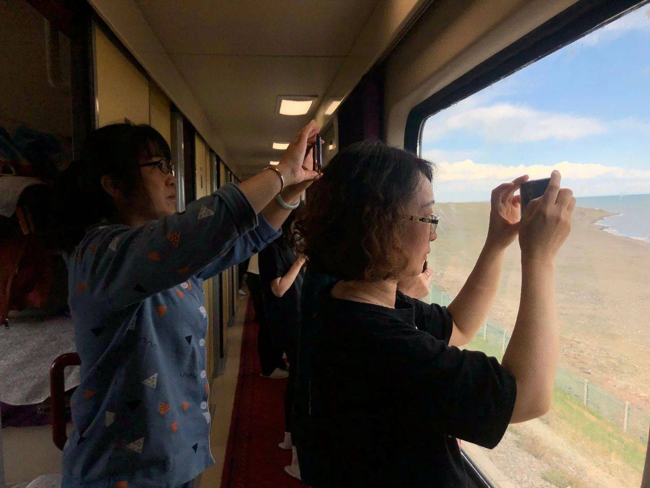 6月4日,z21次列车上,旅客不舍错过窗外每一处风景.