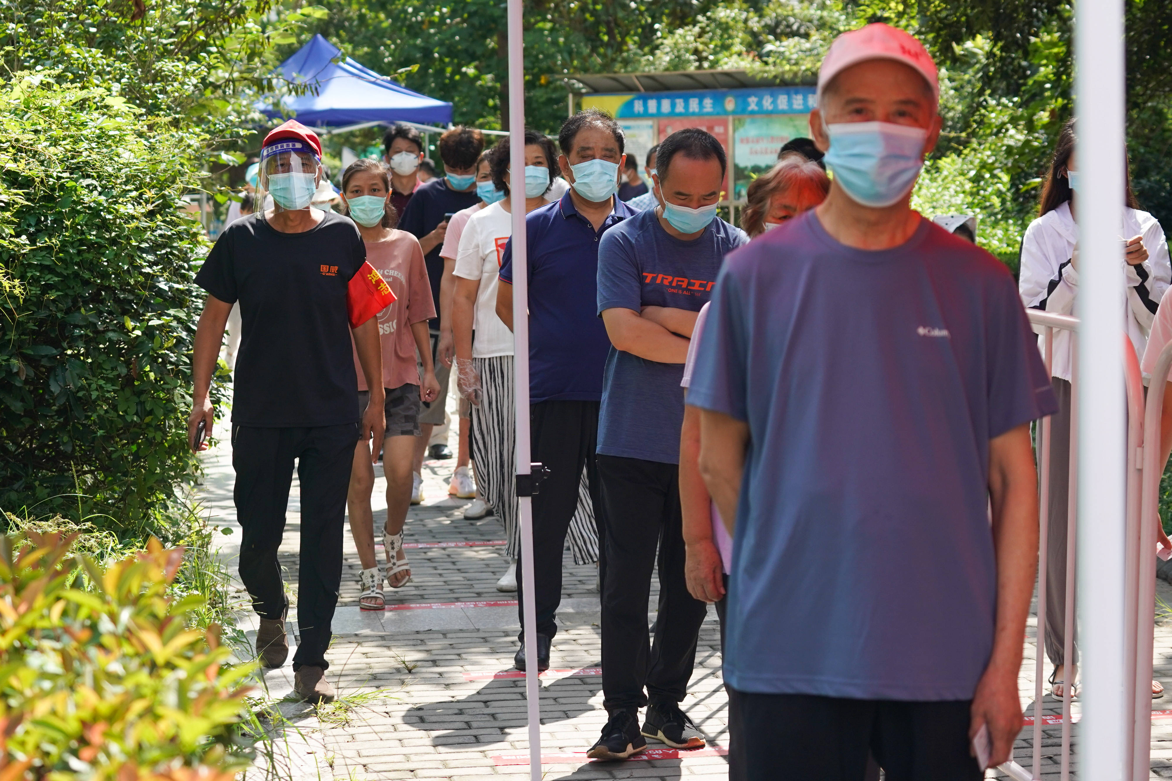 街道鸿福二村核酸采样点,志愿者引导居民有序排队,进行核酸检测取样