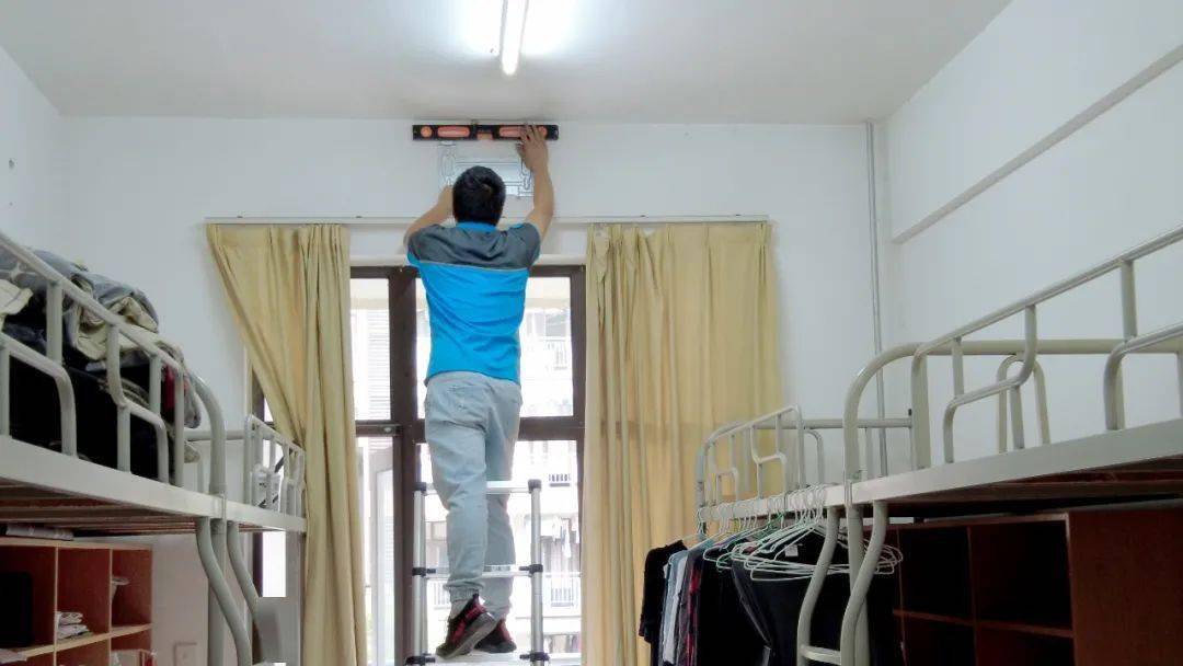 工作人员在宿舍楼道内调试空调设备
