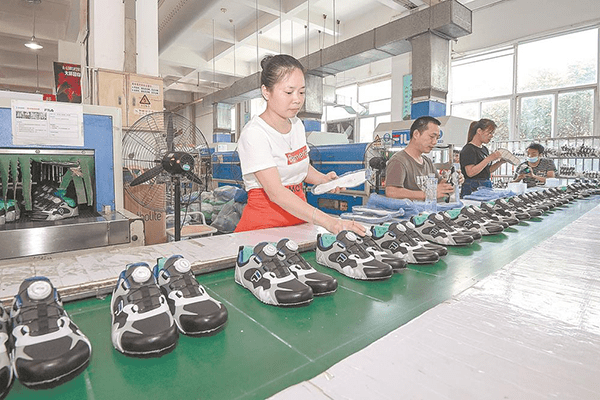 在晋江市的安踏体育公司一车间里,工人在制鞋生产线上操作.