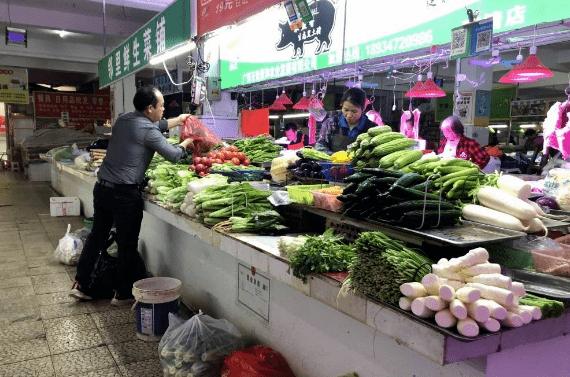 在官塘市场,摊主刚刚把进货的蔬菜摆上.