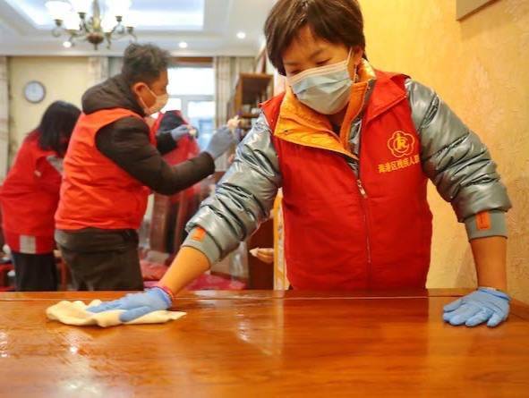 志愿者在燕大西苑社区居民家中打扫卫生(央广网发 曹建雄 摄)