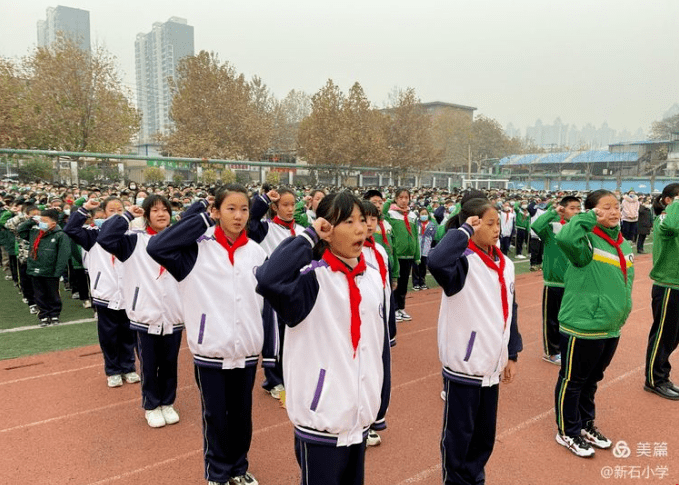 伴随着庄严的国歌声,五星红旗迎着朝阳冉冉升起,新石小学全体师生高唱