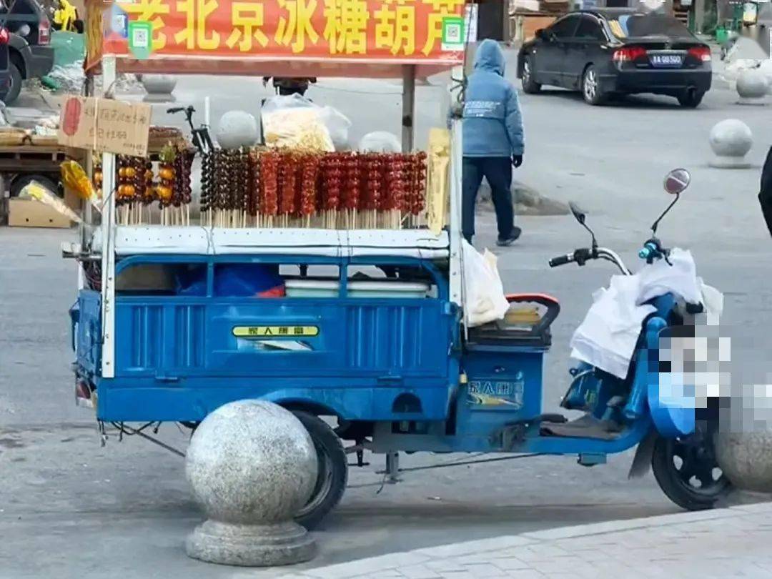糖葫芦的小摊车上的喇叭循环播放着老板的声音但老板不在摊子上也不在