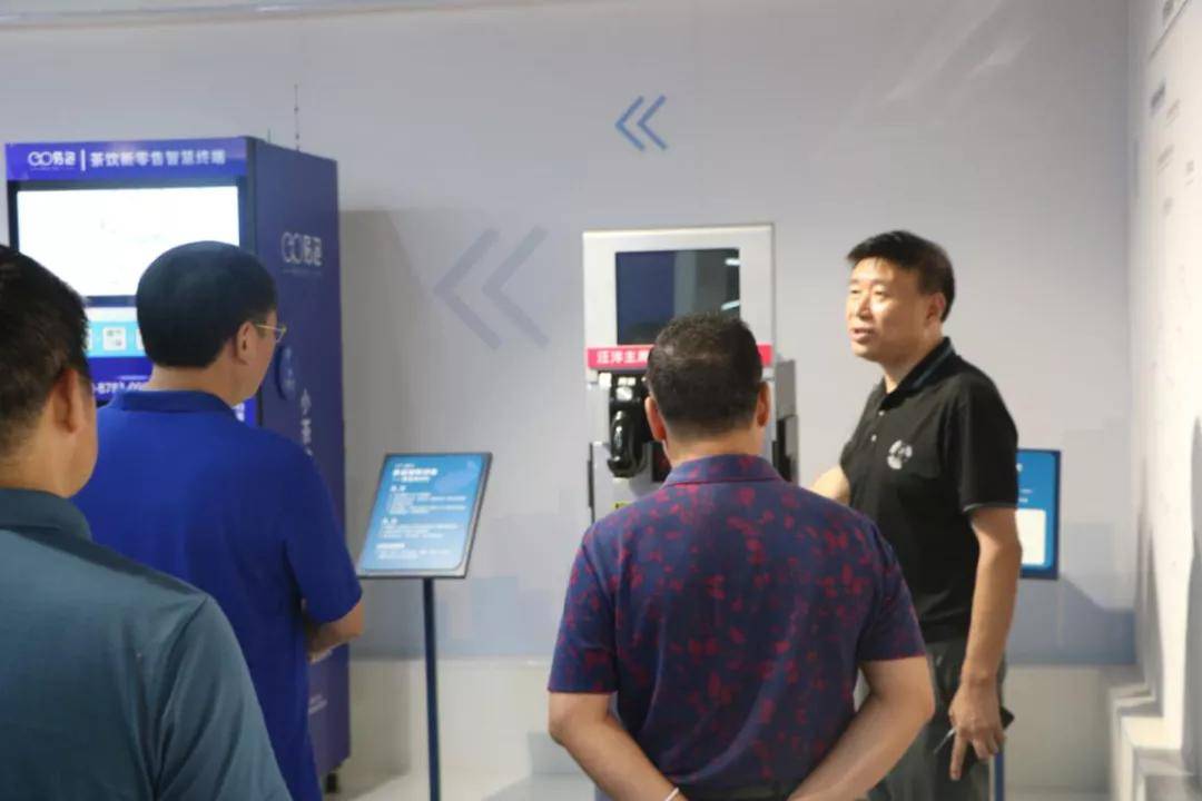 (易泡科技顾问谌再来向领导们解说智慧茶饮机)