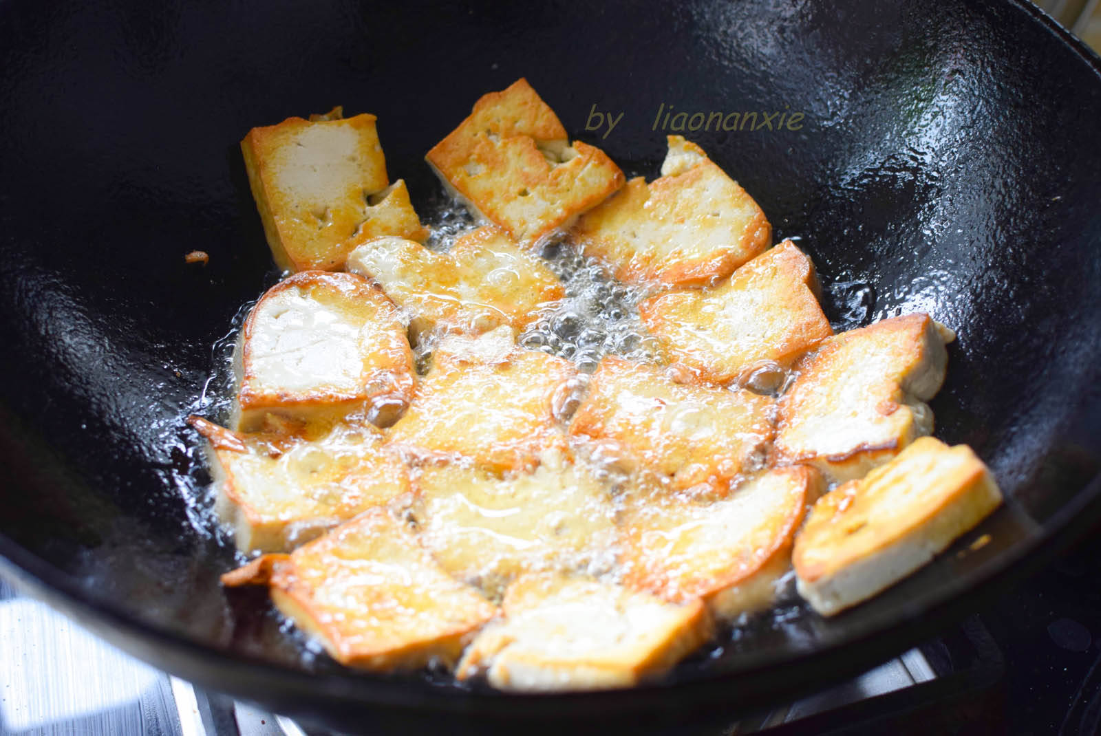 等豆腐煎好后,将虾下锅,可以把豆腐推到一边,用锅中的油把虾炸香.