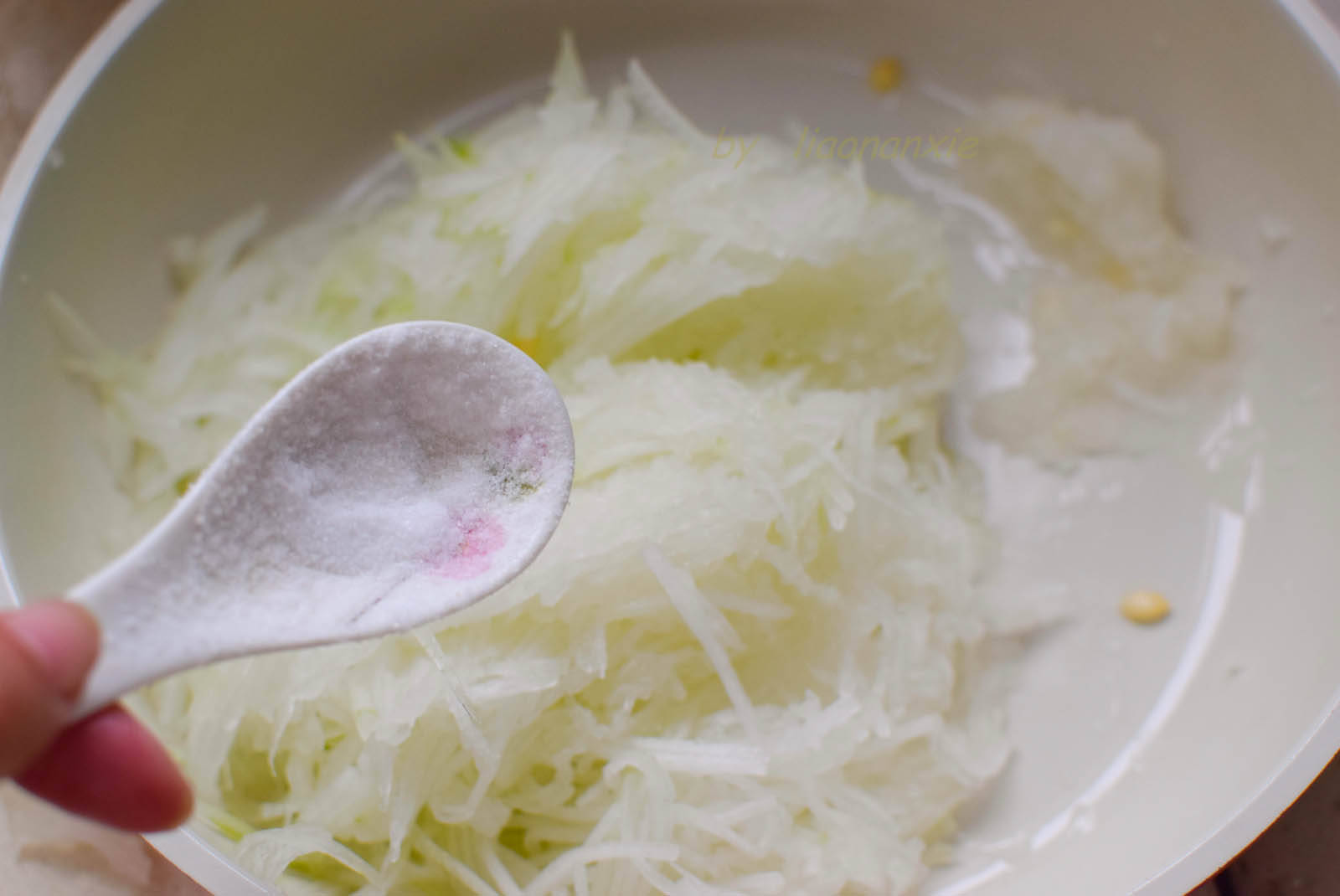 往冬瓜丝中加一点儿盐,拌均匀,稍腌后挤掉水分