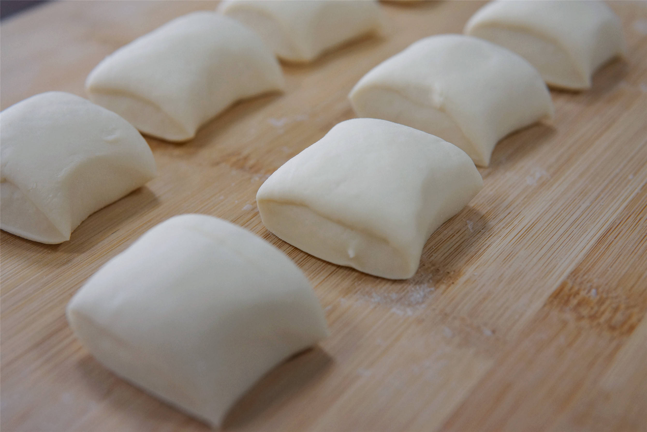 第四步:面剂子擀成圆饼状,将三边折起来呈一个三角形后翻面,中间放一