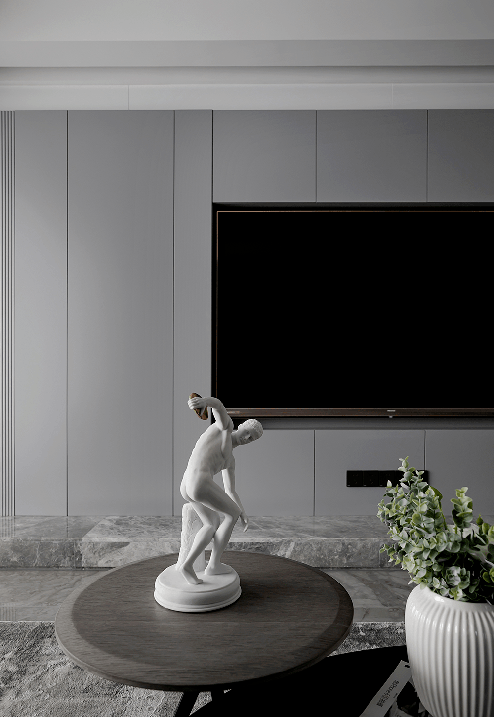 沙发背后灰色护墙板的抽缝处理巧妙的隐藏了主人房门的位置.