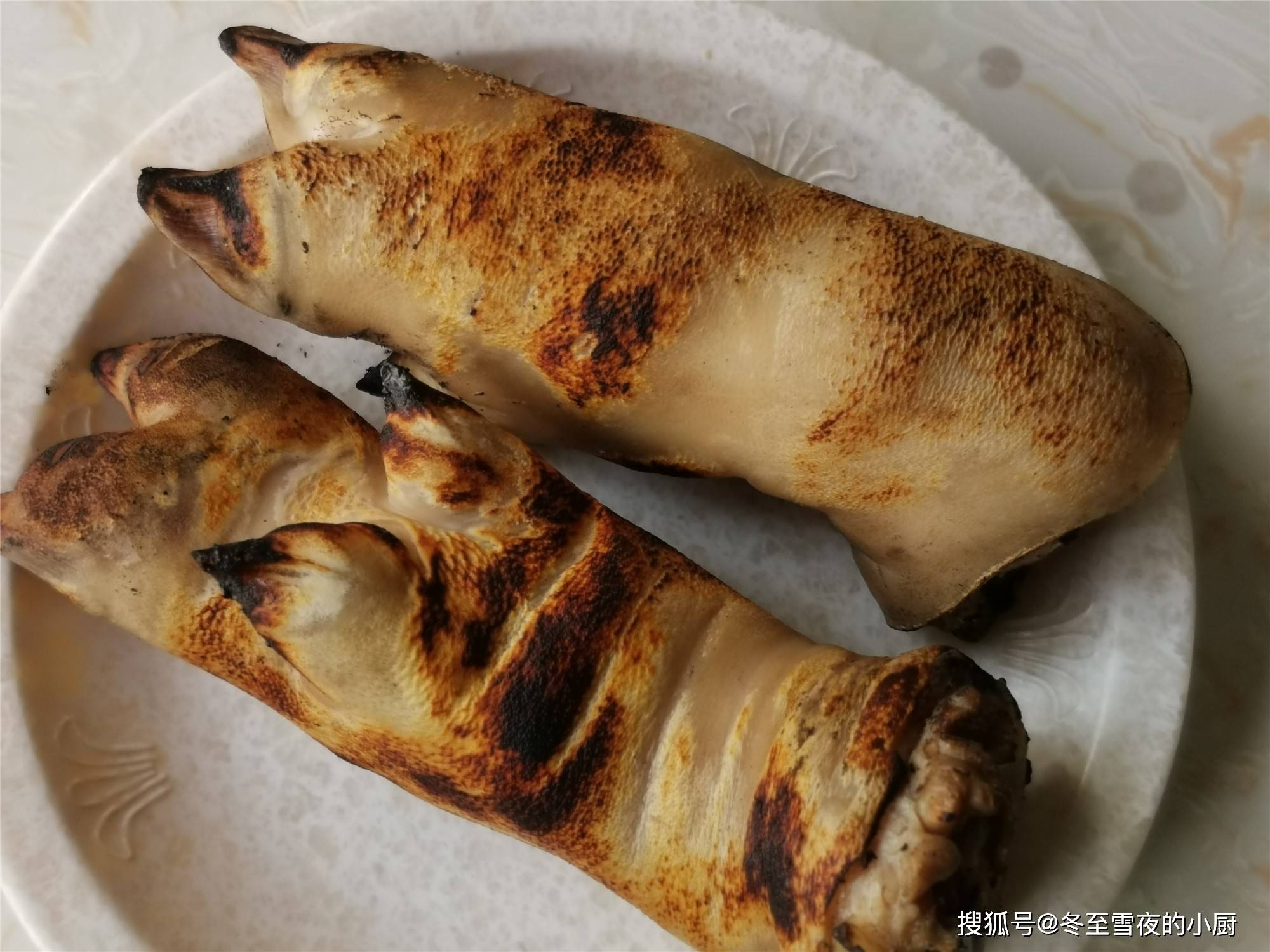 2.把猪爪放在火上烤一下,把表面烤糊,能够把表面的毛给有效的去除.