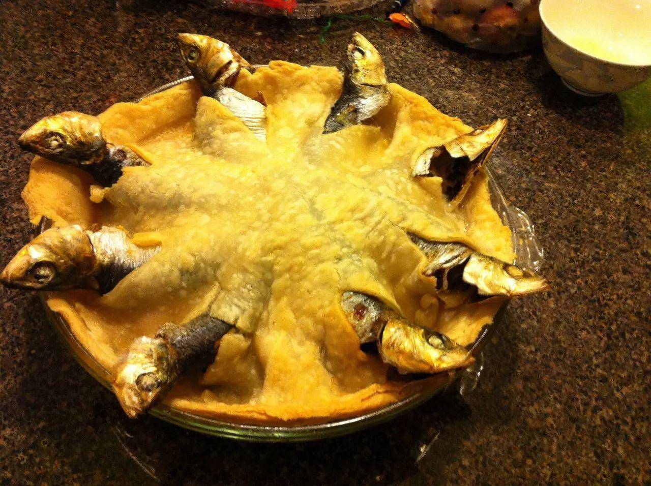 "仰望星空派"这道菜了,盘子里一插着若干条的小鱼,鱼头向着不同的方向