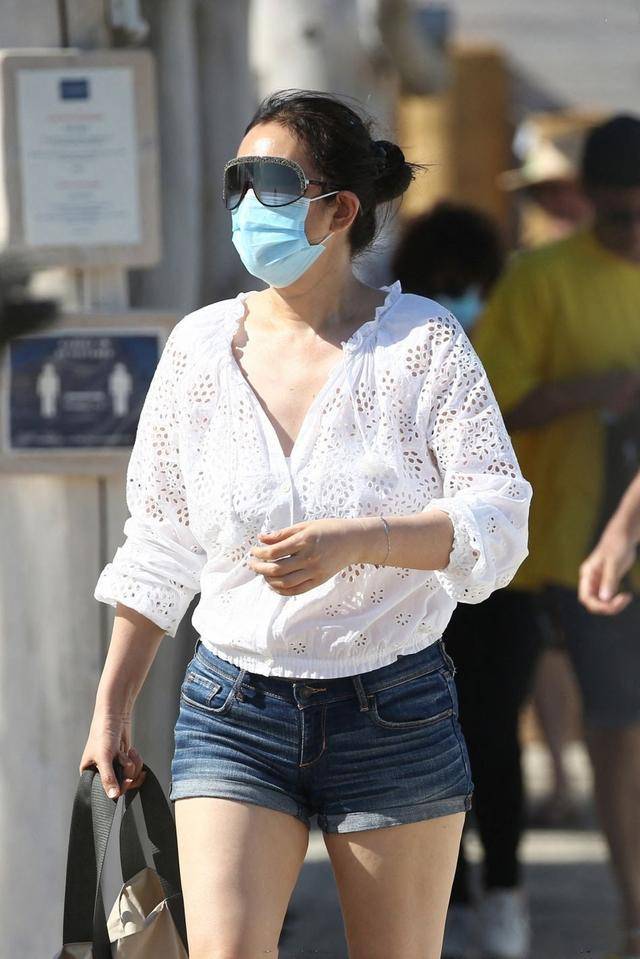 老公|巩俐与老公海边度假,扎丸子头配短裤霸气不再,71岁老公非常时尚