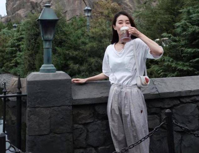 亲姐姐|张小斐打卡“网红景点”，穿白色短袖松松垮垮，目测至少瘦了10斤