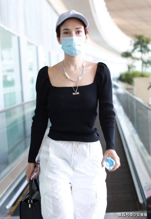 显得 卢靖姗走机场真放得开，方领针织衫硬拽成一字肩，意外时髦洋气