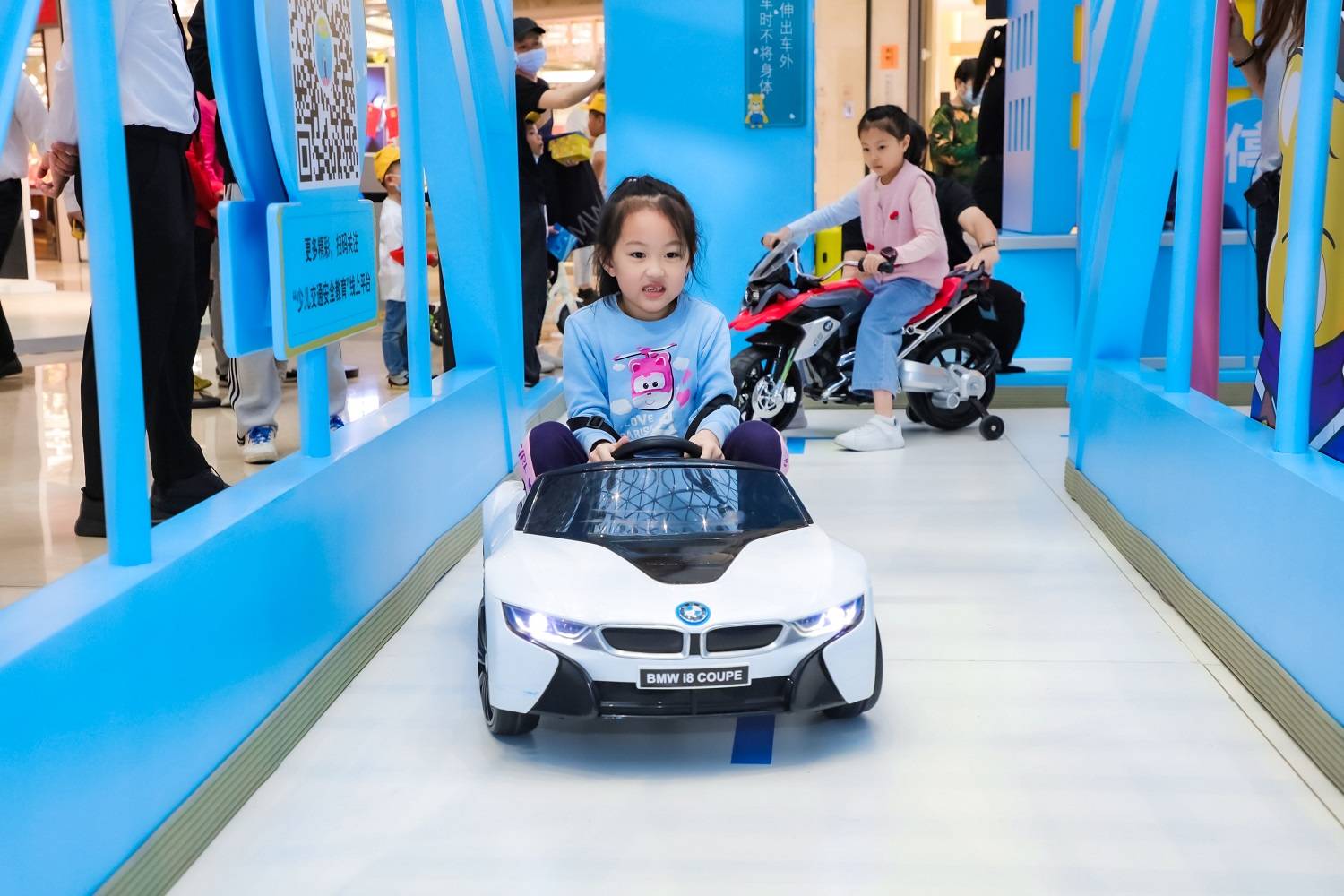 小朋友在"安安驾校"通过驾驶迷你宝马电动车学习交通安全知识