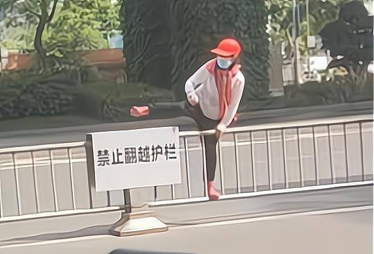 原创成都一女子横穿马路翻越栏杆并转身怒踹禁止翻越护栏警示牌