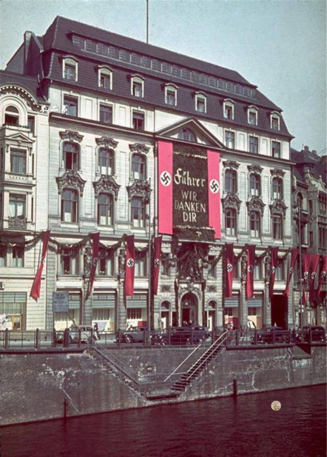 照片拍摄于二战时期,德国柏林的街景,建筑上挂着纳粹卐字旗,从1934年
