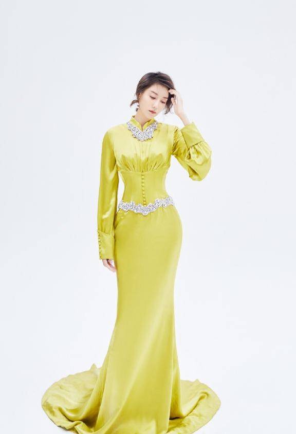 明黄色的丝绸质感礼服长裙上凸显出了高露的好身材,虽然裙子看起来