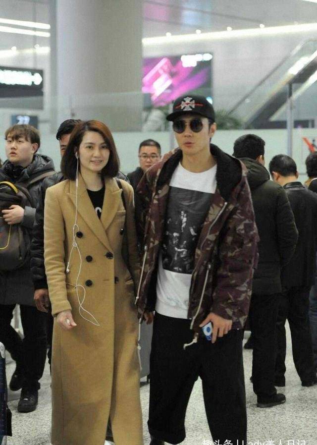 洪欣张丹峰牵手走机场,穿卡其色大衣优雅端庄,老公潮服更吸睛_显得