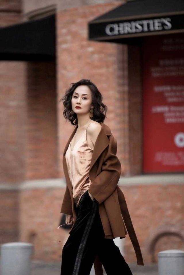 李颖是66年的,化上浓妆,穿上驼色大衣和低胸吊带好性感,美得让人看不