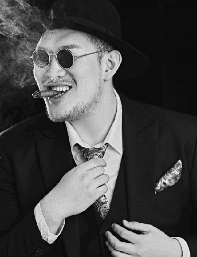 张瑞恒穿着一身西装,带着墨镜和黑色帽子,还叼着烟卷,当他凹pose整理