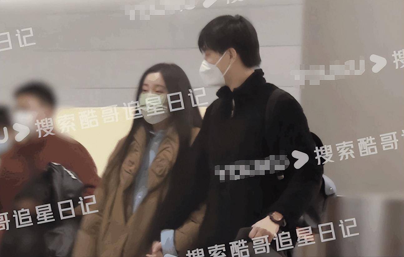 风打扮的李川背着旅行包,一手推着行李箱,一手紧牵女友锤娜丽莎的手