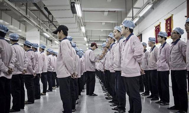 六七个穿厂服的人围坐一桌,其中只有两个女性