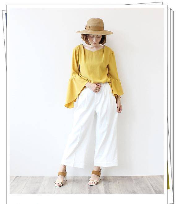 搭配的黄色上衣和白色高腰裙裤在仲夏的阳光下看起来不错.