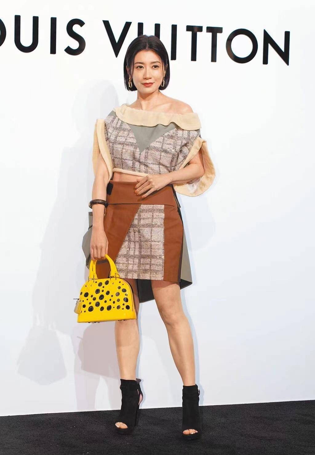 48岁贾静雯出席活动,荷叶边一字肩上衣搭配短裙,时尚又减龄!